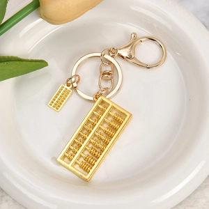 Detailed view of dual golden abacus pendants with metal keychain and lobster clasp