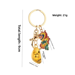 Porte-clés dragon doré avec pendentif lingot et breloque colorée en gros plan détaillé