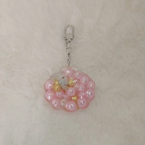 Nahaufnahme des rosa Acryl-Muschel-Schlüsselanhängers mit Perlen und Glitzer-Sand