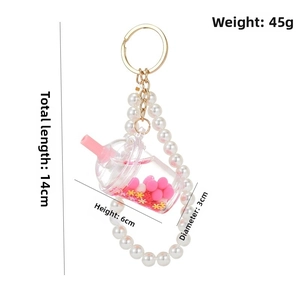 Detail of creative bubble tea keychain with pearls, gold ring, and size measurements