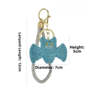Macro detail of bat-shaped keychain with light blue rhinestones and gold clasp