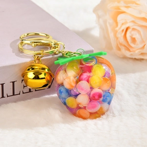 Detailed close-up of a strawberry keychain with colorful beads and a golden bell