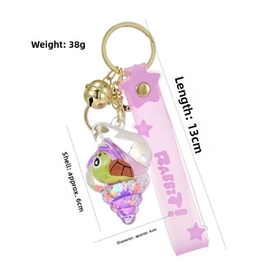Detail of pink keychain showing the seashell pendant with floating sand and green sea turtle