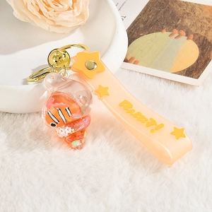 Close-up of creative sea snail keychain with orange shell and internal clownfish mascot