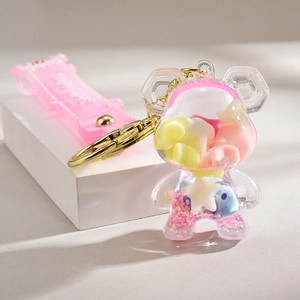 Macro detail of acrylic bear keychain with liquid glitter and pink wrist strap