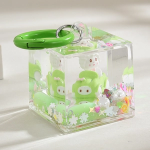Macro detail of acrylic cube keychain with white cartoon doll and green car inside