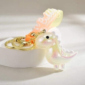 Detailed view of iridescent dinosaur keychain with orange gradient silicone hand strap