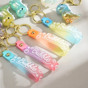 Detail of colorful gradient dinosaur keychains with bubble silicone strap and golden clasp