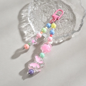 Detailed view of colorful acrylic butterfly beads and flower charms on a lobster clasp