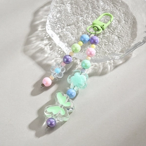 Close-up of colorful beaded phone strap with acrylic butterfly charms and green metal clasp