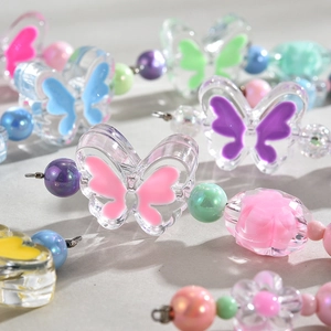 Macro shot of colorful acrylic butterfly beads and imitation pearls for DIY accessories