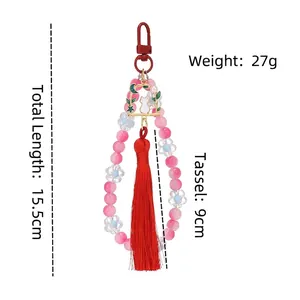 Handmade beaded peach keychain with golden cat charm and 9cm red silk tassel