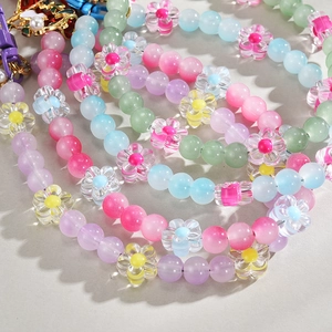 Macro shot of colorful beaded keychain charms with macaron flowers and metallic hooks