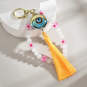 Handmade Evil Eye keychain with blue beads, pink flower charm, and yellow tassel pendant