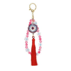 Evil eye beaded keychain with pink beads, red tassel and golden clasp on white backdrop