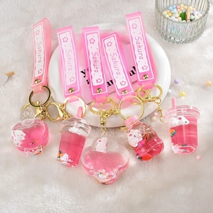 Detail of pink Sakura oil-filled liquid charms with rabbits and golden metal keyrings