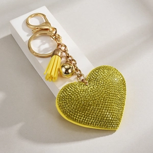 Detail of yellow heart leather keychain with rhinestones, gold tassel, and lobster clasp