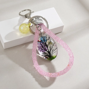 Detailed view of handmade teardrop resin pendant with life tree and dried flowers