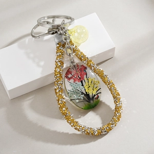 Detailed close-up of a handmade tree of life glass pendant with real dried flowers