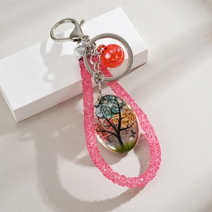 Close-up of tree of life dried flower pendant with pink beaded strap and silver clasp