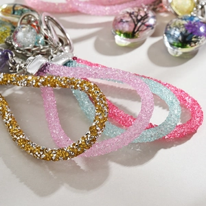 Detailed close-up of sparkling rhinestone braided straps and tree pattern pendant