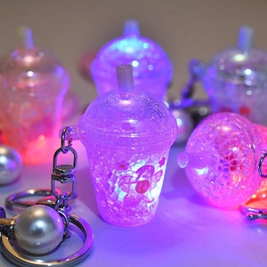 Close-up of luminous mini cup keychain with LED lights, floral print, and pearl charm