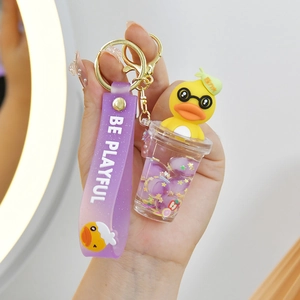Detail of yellow duck charm keychain with purple liquid bottle and silicone wrist strap