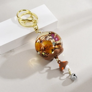 Détail du porte-clés boule en résine fleurs séchées avec champignon et cloche