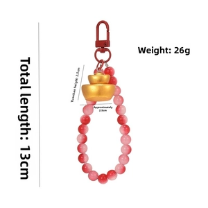 Detail of red beaded keychain with golden ingot pendant and 13cm length dimension