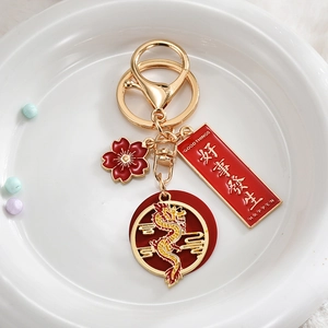 Detailed view of Chinese zodiac dragon keychain with red enamel and gold Good Things Happen tag