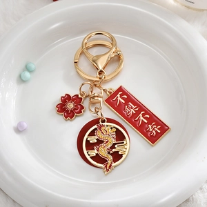 Detail of golden dragon keychain with red enamel charms and lucky Chinese character engraving