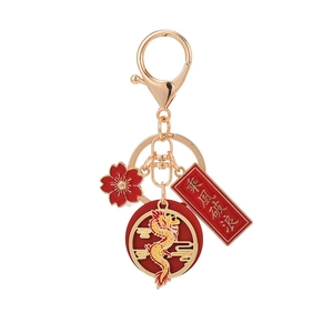 Golden dragon keychain with red floral charm and lucky inscription on white background