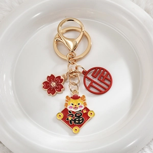 Chinese New Year dragon keychain with red floral charm and lucky symbols on white fur