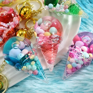 Detailed macro view of acrylic ice cream keychain with colorful floating beads and golden bell