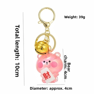 Detailed view of pink jelly bear keychain with gold bell and lucky character charm
