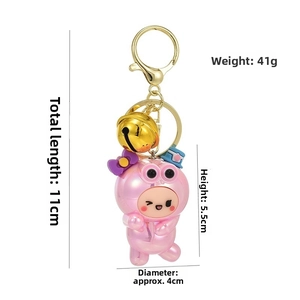 Vue détaillée du porte-clés figurine rose avec clochette dorée et dimensions indiquées