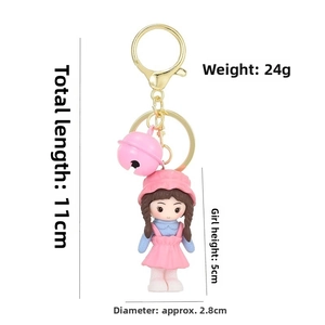 Détail du porte-clés poupée fille rose avec dimensions sur fond blanc épuré