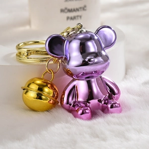 Close-up of gradient purple acrylic bear keychain with gold bell and metallic finish