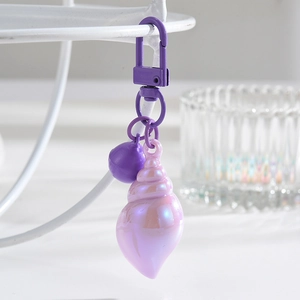 Detail of colorful seashell keychain with purple pearl luster and a matching round bead