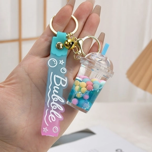 Blue liquid tea cup keychain with astronaut charms and purple silicone wrist strap