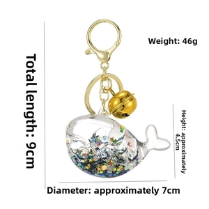 Detailed view of whale keychain with liquid glitter, sequins, and size measurements
