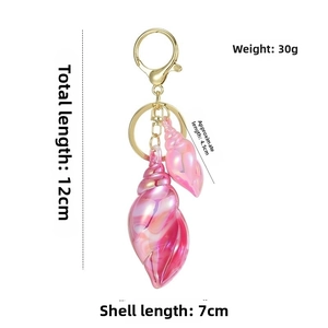 Detailed view of iridescent pink conch keychain with 12cm length and gold hardware