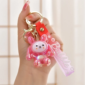 Detailed view of a glowing pink rabbit keychain with pearl finish and a red wrist strap