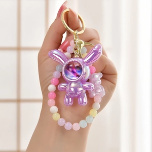 Close-up of a purple starry astronaut bunny keychain with colorful beaded wrist strap