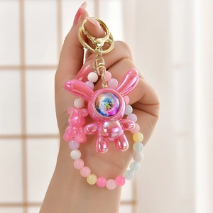 Close-up of pink electroplated astronaut rabbit keychain with colorful macaron bead strap