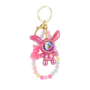 Pink astronaut bunny keychain with iridescent finish and colorful beaded strap charm