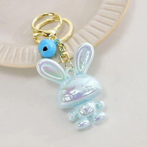 Macro shot of iridescent blue acrylic bunny keychain with LOVE relief and golden heart bell