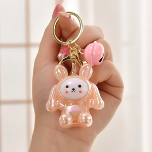 Close-up of laser pink acrylic bunny keychain with metal bell and golden ring clip