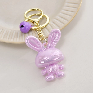 Close-up of purple pearlescent rabbit keychain with golden bell and LOVE engraving