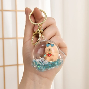 Macro view of Capybara liquid keychain featuring glitter sequins and small strawberry
